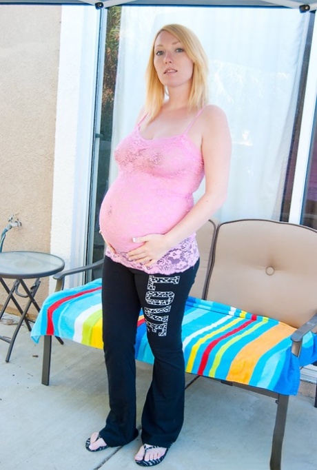 Pregnant blonde holds her swollen belly and milk filled boobs as well 21480781